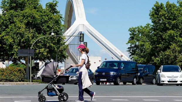 ep una madre pasea a su hijo con el puente de la barqueta detras un dia despues de que el gobierno