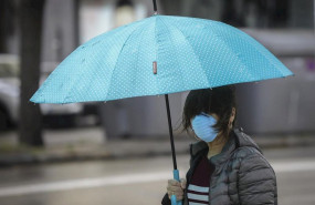 ep una mujer protegida con mascarilla y guantes se resguarda de la lluvia bajo su paraguas en la ep una mujer protegida con mascarilla y guantes se resguarda de la lluvia bajo su paraguas en la