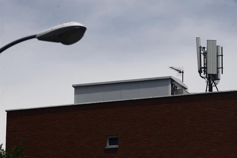 ep imagen de una farola y una antena de telefonia en el tejado de una casa en la ciudad de madrid