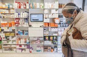 ep una mujer acude a una farmacia para recoger una mascarilla durante el reparto de mascarillas