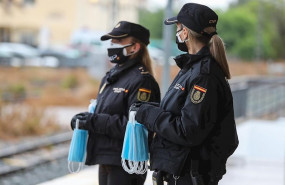 ep policias nacionales se preparan para entregar mascarillas a los viajeros que esperan en un anden