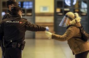 ep un policia nacional entrega una mascarilla a una mujer en el vestibulo de la estacion del norte