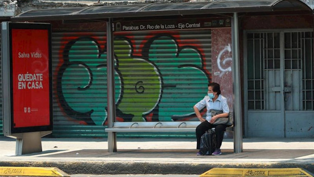 ep una mujer con mascarilla espera en una parada de autobus en ciudad de mexico