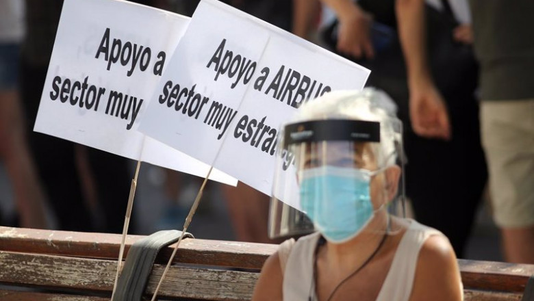 Una mujer protegida con mascarilla y pantalla sentada en un banco donde hay dos carteles en los que se puede leer "Apoyo a Airbus, sector muy estratégico" durante una manifestación de los empleados de Airbus en Getafe (Madrid) el pasado 23 de julio | Eduardo Parra - Europa Press - Archivo ep una mujer protegida con mascarilla y pantalla sentada en un banco donde hay dos carteles en los