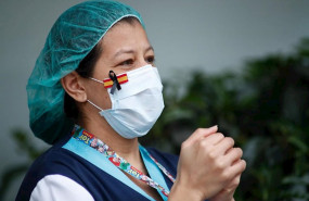 ep una sanitaria con una mascarilla que muestra una bandera de espana con un lazo negro de luto por