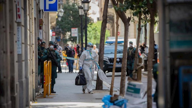 ep agentes de la guardia civil totalmente protegidos salen de un domicilio de la calle de josep
