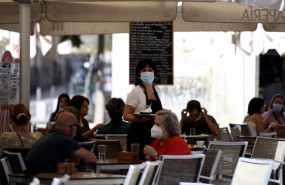 ep archivo   una camarera con mascarilla atiende a los clientes en una terraza de un bar el dia en