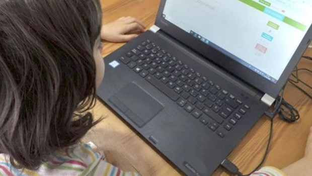 ep una nina realizando tareas escolares desde un ordenador portatil