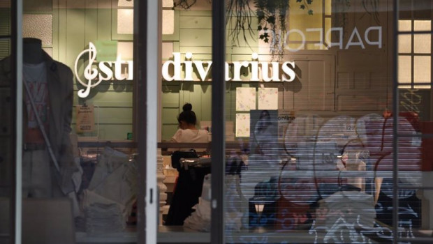 ep una trabajadora protegida con mascarilla coloca los productos en una tienda de stradivarius