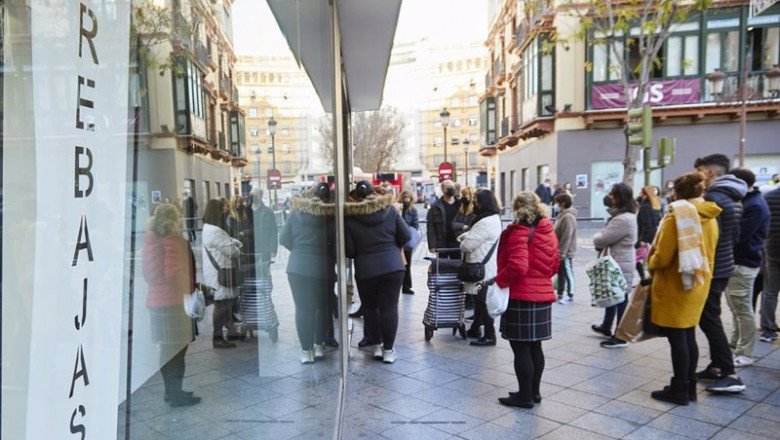 Joaquin Corchero - Europa Press ep detalle de un cartel de rebajas y varias personas esperando que abran los negocios durante el