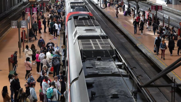 ep numerosas personas con maletas esperan en el anden la salida de un tren en la estacion almudena