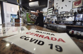 ep un camarero coloca carteles en su barra cerrada por covid en su bar el dia en que han entrado en