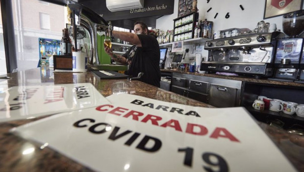 ep un camarero coloca carteles en su barra cerrada por covid en su bar el dia en que han entrado en