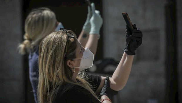 ep dos personas protegidas con mascarillas y guantes graban con sus moviles durante el estado de