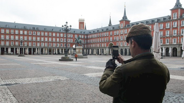 Un hombre hace una foto con su móvil a la céntrica Plaza Mayor de Madrid, vacía durante el estado de alarma decretado por el coronavirus, en Madrid (España) | Joaquin Corchero / Europa Press ep un hombre hace una foto con su movil a la centrica plaza mayor de madrid vacia durante el estado