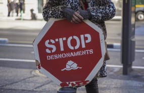 ep archivo   una persona sujeta un cartel de stop desnonamients durante una concentracion de la