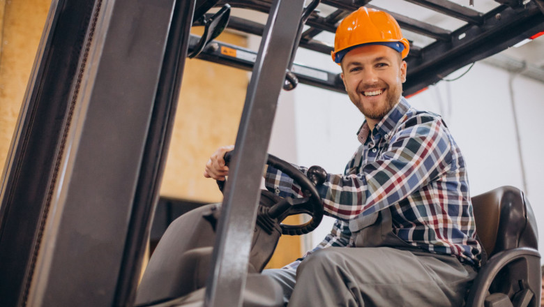 man working warehouse driving forklift 