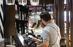 ep dos camareros cobran las cuentas de los clientes en un bar de madrid