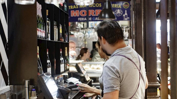 ep dos camareros cobran las cuentas de los clientes en un bar de madrid