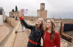 ep dos turistas se hacen una foto en la alcazaba con la torre de espantaperros de fondo