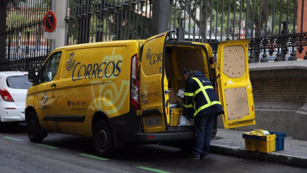 ep un trabajador de correos extrae de su furgoneta paquetes y cartas
