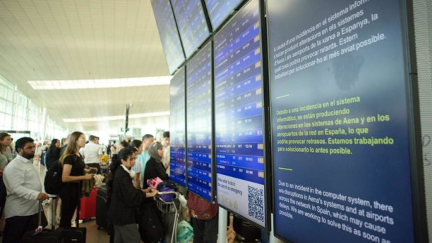 ep colas de pasajeros ante una pantalla que avisa de la incidencia informatica en el aeropuerto de