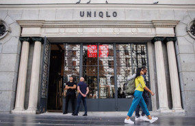 ep archivo   dos personas pasan por delante de la entrada de una tienda uniqlo en la gran via la