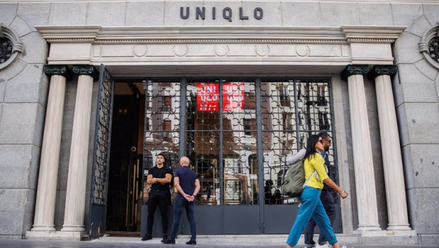 ep archivo   dos personas pasan por delante de la entrada de una tienda uniqlo en la gran via la