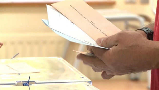 ep un elector con las papeletas junto a la urna