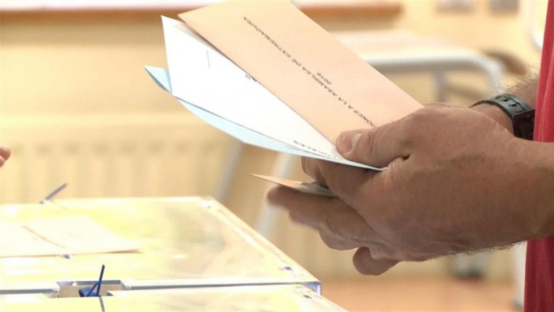 ep un elector con las papeletas junto a la urna