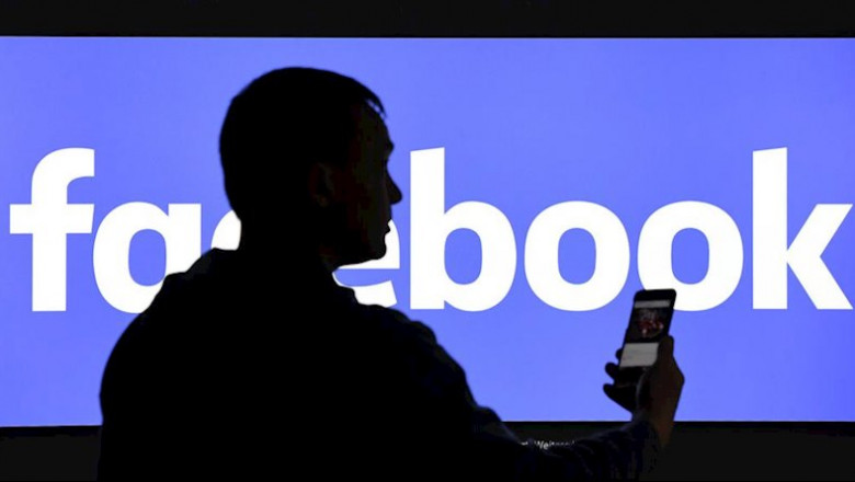 ep un hombre con un telefono movil delante de un cartel de facebook ep un hombre con un telefono movil delante de un cartel de facebook
