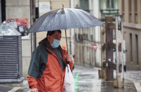 ep un hombre con mascarilla camina bajo la lluvia junto al vallado permanente del encierro de