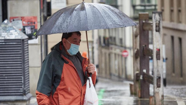 ep un hombre con mascarilla camina bajo la lluvia junto al vallado permanente del encierro de