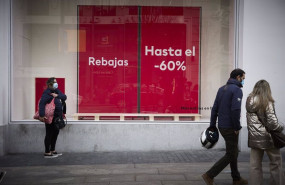 ep archivo   varias personas pasan delante de un escaparate con cartel de rebajas en una calle