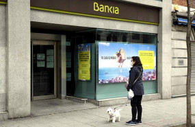 ep una mujer pasea con un perro frente a una sucursal de bankia un dia despues de que banco central