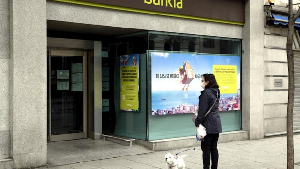 ep una mujer pasea con un perro frente a una sucursal de bankia un dia despues de que banco central