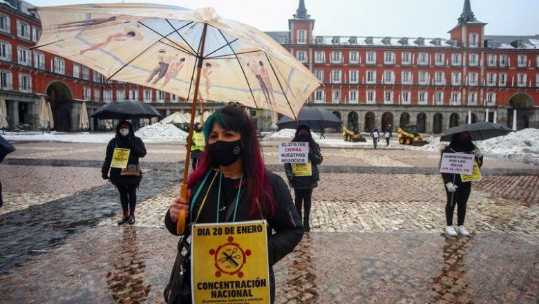 Una mujer sostiene un paraguas y una pancarta en la protesta convocada por el sector de la estética y peluquería para pedir la bajada del IVA al 10%, en Madrid, (España). | Ricardo Rubio - Europa Press ep una mujer sostiene un paraguas y una pancarta en la protesta convocada por el sector de la