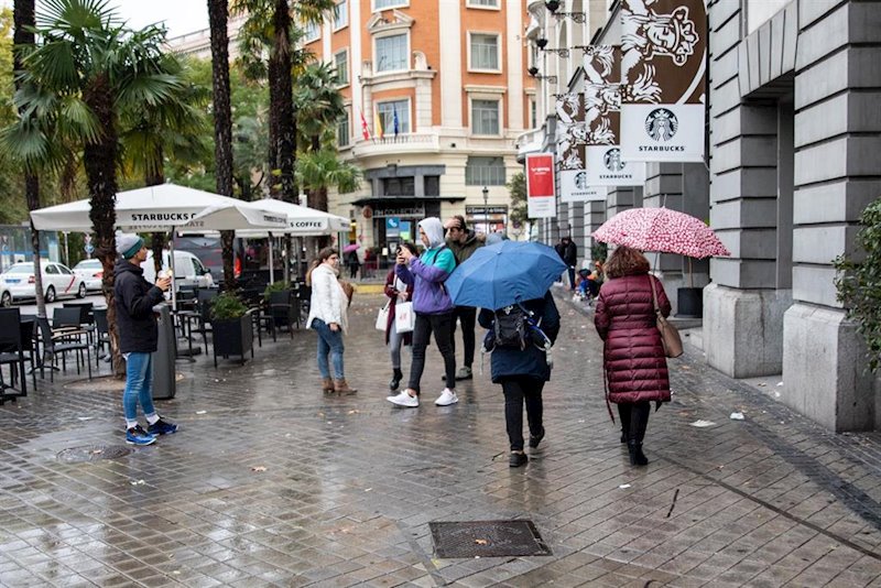 ep varias personas pasean por la calle con un paraguas debido a la lluvia