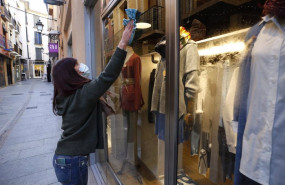 ep una dependienta limpiando un escaparate de una tienda